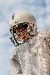 Foto op Plexiglas Young boy in a football uniform with his game face on © soupstock
