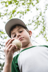 Pic of young boy holding a baseball getting read to pitch