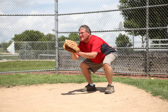 Father coach being catcher at a baseball practice