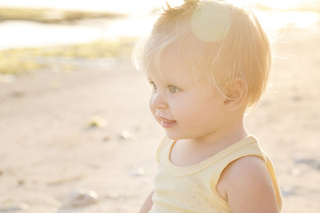 
Candid outdoor portrait of cheerful baby at the beach, natural backlight photo