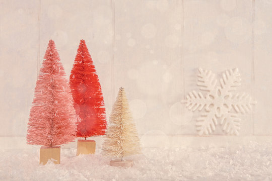 Image of miniature Christmas trees on a vintage textured wooden background