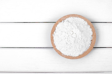 Flour on wooden plate over the white table