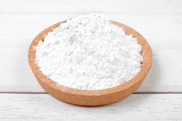 Flour on wooden plate over the white table