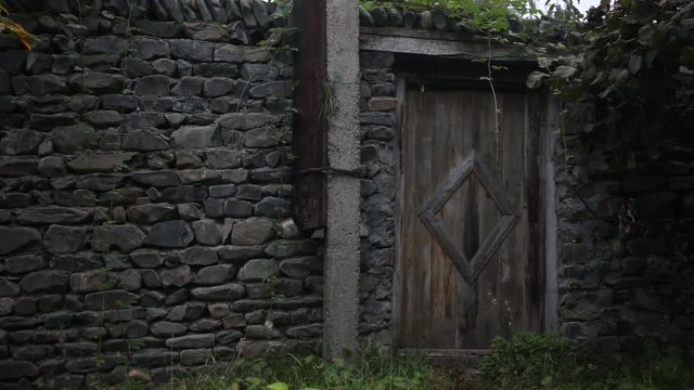 Wooden door of an old stone building. brown wooden, double door with white stone wall edging.