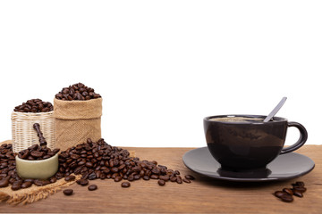 Hot cup of coffee  and beans with burlap sack on the wooden table, with copy space