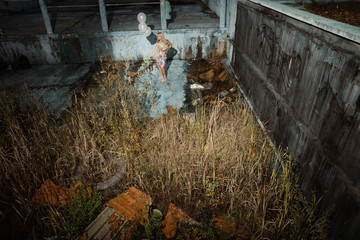 Beautiful lady with balloons in abandoned swimming poll