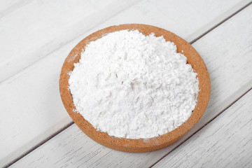 Flour on wooden plate over the white table