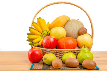 Composition with assorted fruits in wicker basket on wooden table, balanced diet, copy space