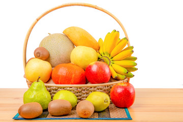 Composition with assorted fruits in wicker basket on wooden table, balanced diet, copy space