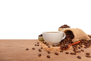 Hot cup of coffee  and beans with burlap sack on the wooden table, with copy space