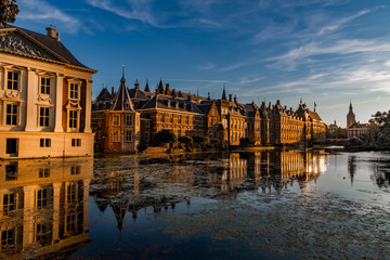 Relection of the Buitenhof, Binnenhof buildings, Dutch parliament campus under a clear blue sky in The Hague, Netherlands