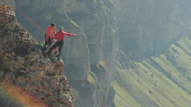 A group of climbers discussing a plan of action standing on the edge of the cliff.