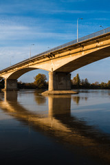 Fototapeta na wymiar Bridge over river. Sunlight and reflection in the water