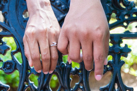 Manos entrelazadas de hombre y mujer enamorados. Mano de mujer con anillo de compromiso