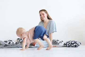 Laughing cute toddler boy learns to run. A small two-year-old kid runs away from his young cute...
