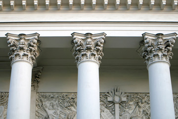 Three corinthian columns supporting the cornice of the church, white bulding in greek style
