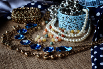 Blur Jewelry in a box. Jewelry bead, earrings chains on a brown Sack background. Design, fashion and style of jewelry.