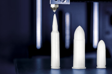 Patronen und Revolvertrommel werden in einem 3D Drucker gedruckt, Konzepte wie Waffenhandel und Waffenproduktion, Gefahren durch neue Waffentechnologien