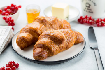 Continental breakfast. Coffee, orange juice, croissants, jam and butter. White stone background. 