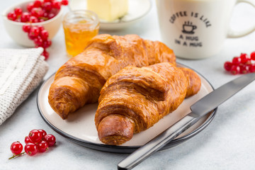 Continental breakfast. Coffee, orange juice, croissants, jam and butter. White stone background. 