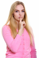 Naklejka premium Studio shot of young beautiful teenage girl with finger on lips