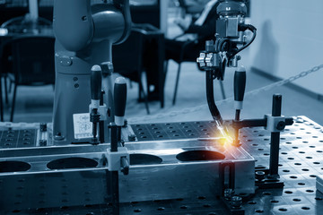 The welding robot machine for welding automotive part in the light blue scene.Industrial 4.0...
