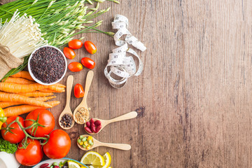 Healthy food background ,fruits and vegetables with salad bowl and measuring tape  on wooden table.