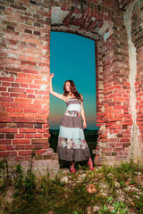 Attractive girl in a dress posing in a labyrinth of ruins. Social networks lifestyle concept