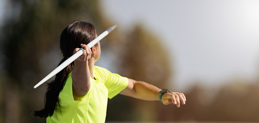 Female athlete throwing a javelin, rear view