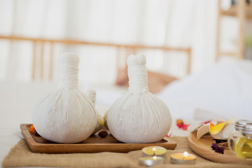 Selective focus Herbal compress balls with oil, on the wooden table in spa salon.  alternative...