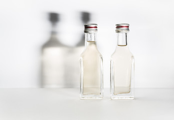 Two bottles of vintage alcohol with shadows on the wall.