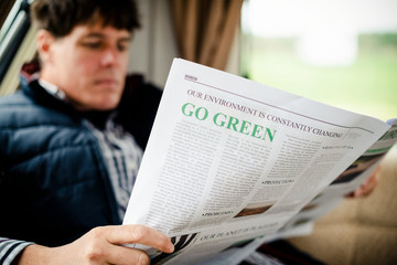 Naklejka premium Man reading a newspaper at home
