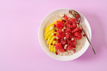 Delicious and healthy oatmeal with grapefruit, pomegranate, almond and chia seeds.  Healthy breakfast. Fitness food. Proper nutrition. Flat lay. Top view.