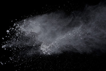 White powder explosion on black background. Dust splatted isolated. Paint Holi.