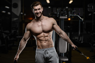 sexy strong bodybuilder athletic men pumping up muscles with dumbbells