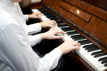 Children play piano in four hands