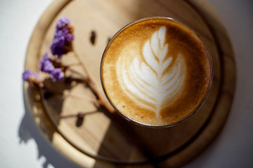 cup of coffee with cream on wooden background