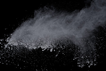 White powder explosion on black background. Dust splatted isolated. Paint Holi.