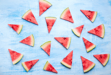 triangular ripe Watermelon slices on blue wooden table. Top view, flat lay. vegan healthy food concept