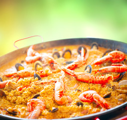 Paella. Traditional spanish food, seafood paella in the fry pan with mussels, king prawns, langoustine and squids. Cooking paella outside