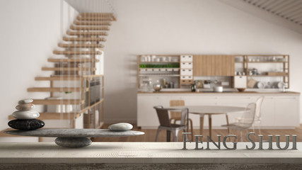 Wooden vintage table shelf with stone balance and 3d letters making the word feng shui over minimalist white wooden kitchen, loft with stairs, zen concept interior design