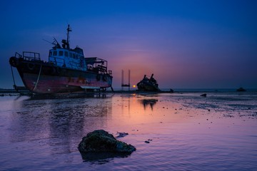 Naklejka premium ship in the sea at sunset