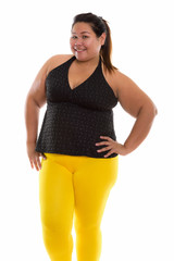 Studio shot of young happy fat Asian woman smiling and standing 