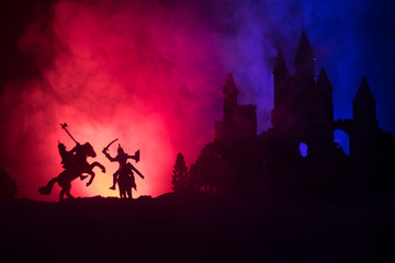 Silhouettes of figures as separate objects, fight between warriors on dark toned foggy background...