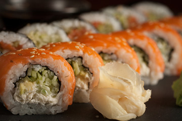 Maki rolls and nigiri sushi on a wooden table. Salmon, avocado and caviar rolls.