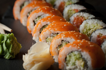 Maki rolls and nigiri sushi on a wooden table. Salmon, avocado and caviar rolls.