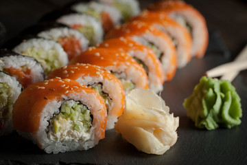 Maki rolls and nigiri sushi on a wooden table. Salmon, avocado and caviar rolls.
