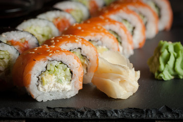 Maki rolls and nigiri sushi on a wooden table. Salmon, avocado and caviar rolls.