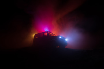 Police car chasing a car at night with fog background. 911 Emergency response police car speeding to scene of crime.