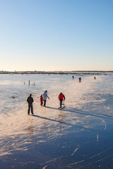 Ice skating and a kicksled at a frozen lake